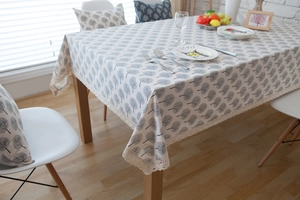 Detail showing grey tree pattern and beige lace trim on a minimalist linen tablecloth