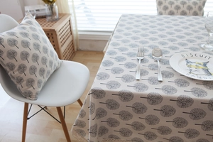 Detailed texture of beige linen cushion with gray tree patterns in a cozy dining setting