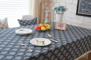 Detail of dark grey tablecloth with white tree patterns and beige lace borders