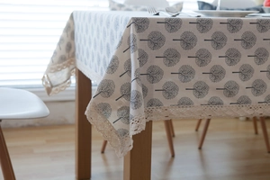 Close-up of minimalist tree print linen tablecloth with delicate lace edging and texture