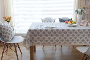 Detail of linen blend tablecloth with tree patterns and delicate lace trim on edges