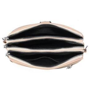 Detail view of the apricot crossbody bag with three zipper compartments and lychee texture