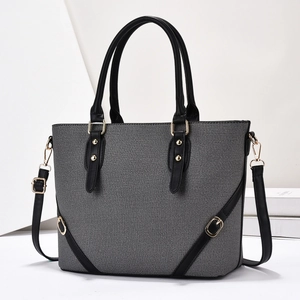 Detail view of the gray denim texture fabric and gold hardware on this tote bag