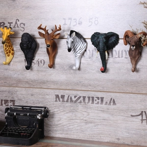 Vista dettagliata dei ganci da parete a testa di animale in resina su sfondo in legno