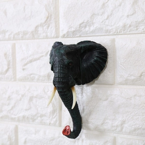 Dettaglio gancio da parete a forma di testa di elefante realistica con zanne bianche