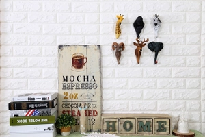 Dettaglio dei ganci da parete vintage a testa di animale con giraffa e zebra sul muro
