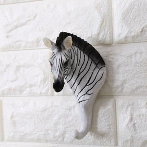 Dettaglio di un gancio da parete creativo a testa di zebra con strisce bianche e nere