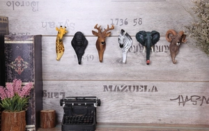 Dettaglio di ganci in resina dipinti a mano con giraffa e zebra su legno vintage