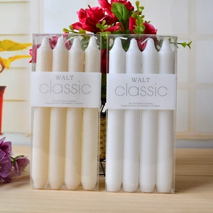 Close-up of four-pack smokeless white tapered candles on a wood table with flowers