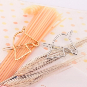 Detailed close-up of hollow geometric horse head hair clips in gold and silver metal