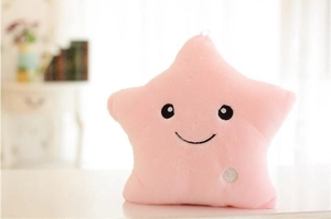 Detail of soft pink plush star pillow featuring an ON/OFF button for LED lighting function