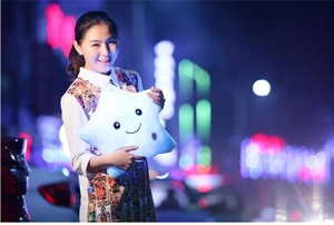 Macro shot of glowing light-up star plush pillow with an embroidered smiling face