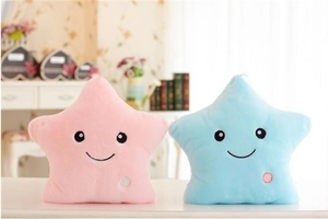 Detail of pink and blue glowing star plush pillows with cute smiles and power buttons