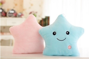 Close-up of pink and light blue plush star pillows with soft texture and cute smile face