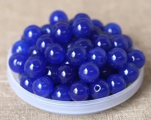Macro shot of dark blue polished round beads with drill holes for DIY jewelry making