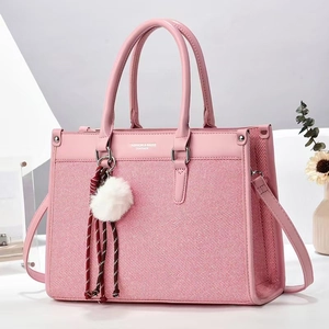 Pink minimalist tote bag with textured fabric and leather straps shown in a bright setting