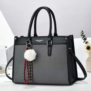 Detail of large black leather and gray fabric tote bag with elegant fashion lettering