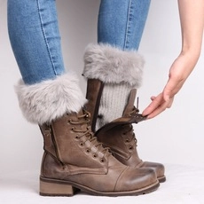 Detail of brown lace-up Martin boots with gray faux fur leg warmers on a model