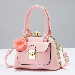 Elegant pink crossbody bag with gold frame, diamond knob and rose charm accessory
