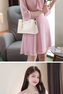 Chic cream leather handbag with heart charm and zipper detail on pink chiffon dress