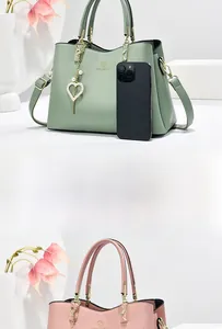 Detailed view of the lychee texture leather and heart pearl pendant on a tote bag