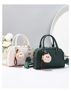 Detail of Boston bags featuring lychee leather texture, cat plush charm, and geometric strap