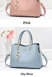 Detail of pink and blue PU leather bags with heart pendants and white pearls