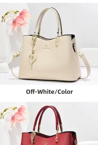 Detail of elegant beige handbag featuring premium textured leather and a heart charm