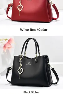 Detail of red and black tote bags with pearl heart charms and brand logo