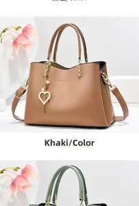 Detail of khaki PU leather handbag featuring a pearl heart charm and metal logo