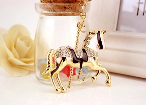 Détail d'un porte-clés carrousel doré orné de strass brillants et d'émail décoratif