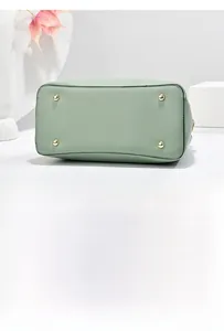 Detailed base view of Morandi green leather handbag featuring golden protective metal feet