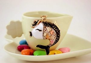 Close-up of enamel koi carp keychain with inlaid cat-eye stones and sparkling rhinestones