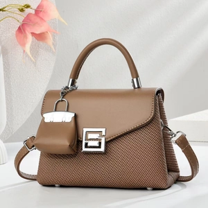 Elegante Handtasche aus karamellfarbenem Leder und braunem Stoff mit Silberschnalle