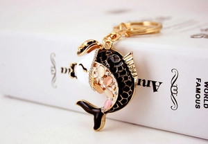 Detailed close-up of a golden koi fish keychain with black, white, and sparkling crystals