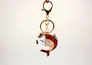 Close-up of golden carp keychain with red hollow body and multicolored gemstones