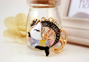 Macro shot of koi fish keychain with black enamel and colorful rhinestones