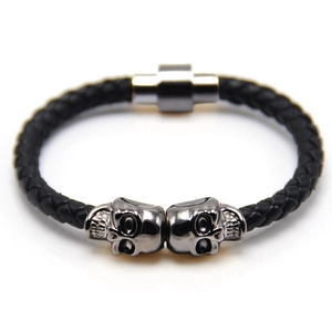 Macro detail of men's punk skull bracelet with black braided leather and magnetic clasp