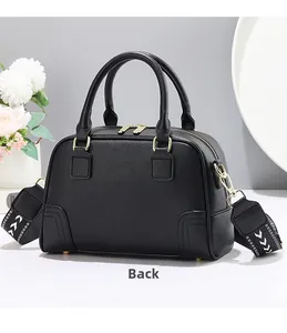 Rear view of black lychee grain leather Boston bag with decorative woven strap and gold hardware