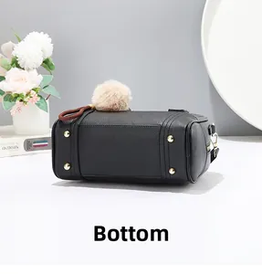 Detail view of handbag bottom featuring four gold protective metal studs and pebble leather
