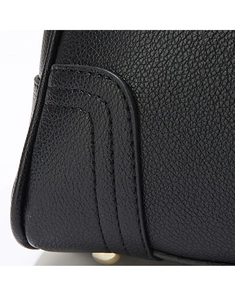 Close-up of black litchi grain leather handbag with gold metal feet and double stitching