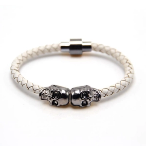 Macro detail of braided leather bracelet with twin skulls and magnetic clasp closure