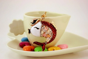 Close-up of golden carp keychain with red and white enamel and sparkling rhinestones