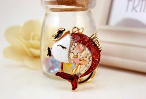 Detail of goldfish keychain featuring enamel craft, cat eye stones and sparkling crystals