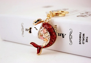 Detail of koi carp metal keychain with red enamel and inlaid cat eye stones and rhinestones