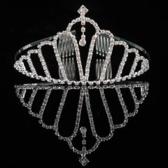 Exquisite bridal crown with silver metal frame and clear rhinestones on reflective black surface