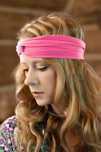 Nahaufnahme des rosa verdrehten Stirnbandes mit weichem Strickstoff und Boho-Knotendesign