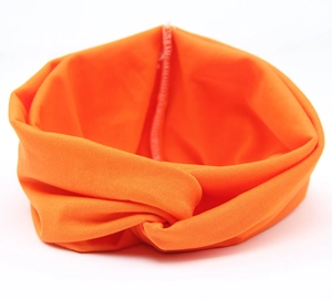 Detail eines orangefarbenen Stirnbands mit Twist-Design und feiner Nahtverarbeitung