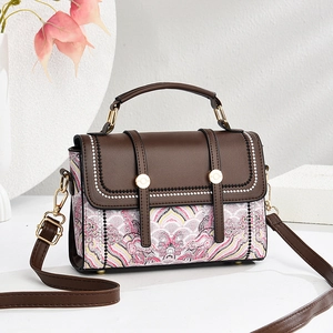 Brown leather and pink print crossbody handbag with top handle on white background