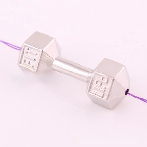 Macro detail of silver barbell pendant with Fit Life engraving for fitness jewelry